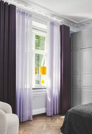 Dobbelt opp av lilla gardiner på soverommet