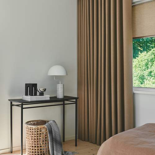 Beige rullegardin i kombinasjon med stoffgardiner